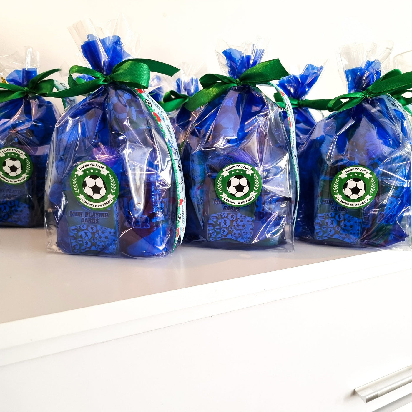 Pre filled football party goody bags with football themed toys and sweets, packed in blue gift bags with football design ribbon.